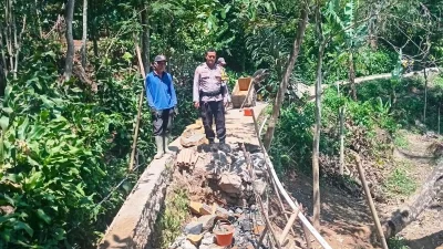 Bhabinkamtibmas Desa Sumurugul Pantau Pembangunan Jalan Terdampak Longsor