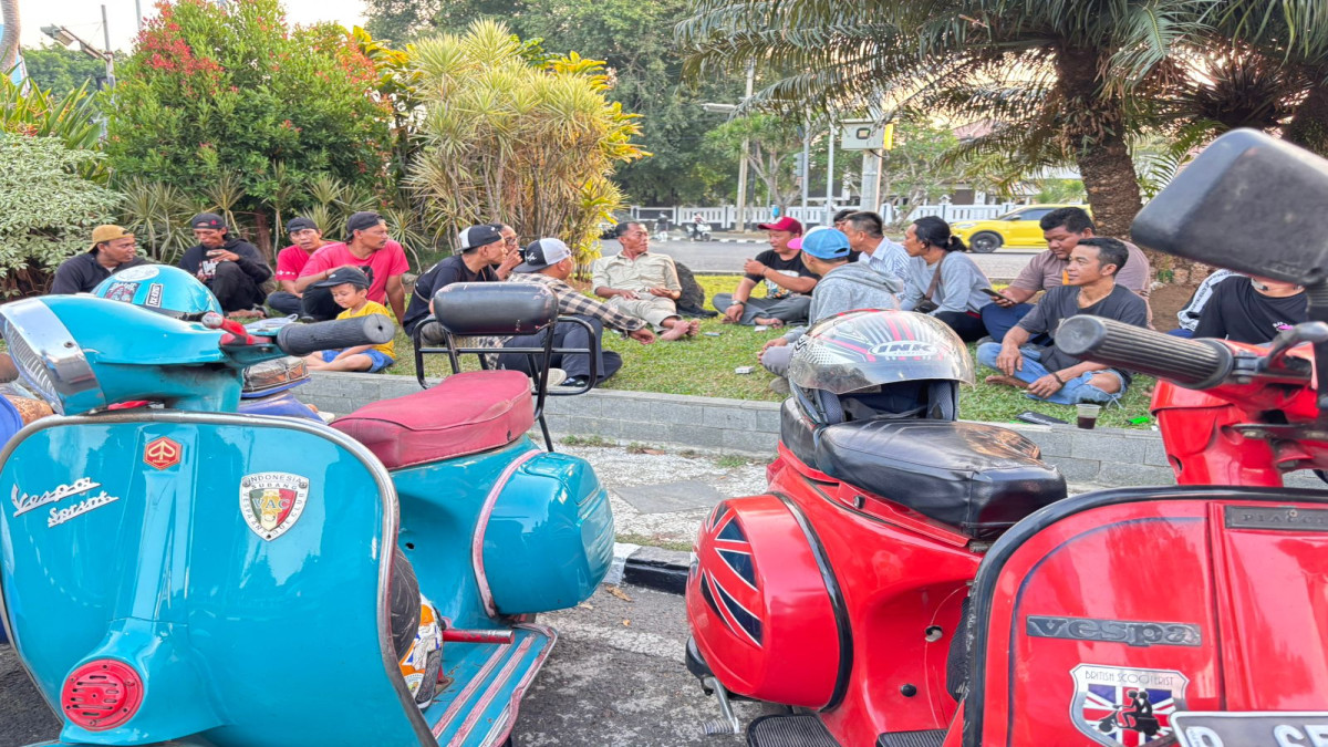 Kang Jimat duduk lesehan di atas hamparan rumput bersama anggota Vespa Unique Club, Sabtu (12/10) di depan Wisma Karya Subang.