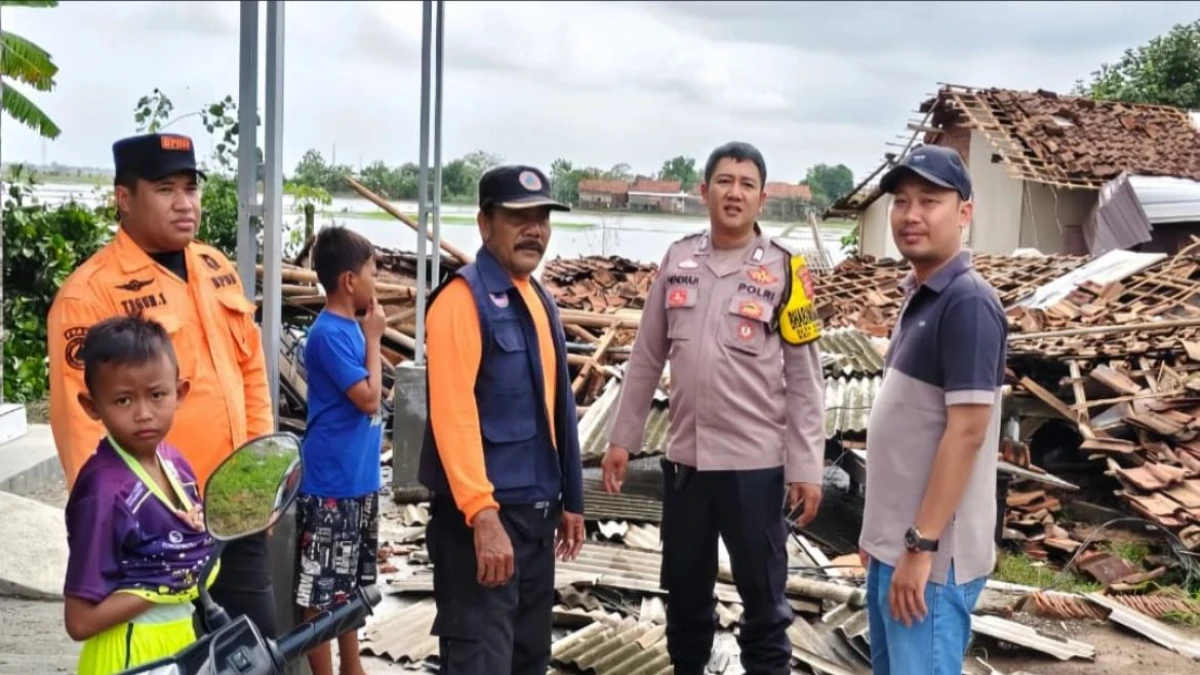 Bhabinkamtibas Desa Karanganyar, Bripka Hendra Hermawan bersama warga saat meninjau kondisi rumah rusak akibat angin puting beliung.